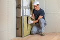 Worker insulating a room wall with mineral rock wool thermal insulation Royalty Free Stock Photo