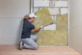 Worker insulating a room wall with mineral rock wool thermal insulation Royalty Free Stock Photo