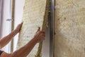 Worker insulating a room wall with mineral rock wool thermal insulation Royalty Free Stock Photo