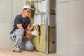 Worker insulating a room wall with mineral rock wool thermal insulation Royalty Free Stock Photo