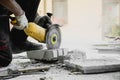 Worker cutting limestone block with power tool saw