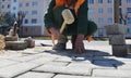 A worker knocks a hammer on the paving slabs. Royalty Free Stock Photo