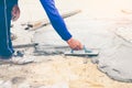 Worker, labor or mason is repairing or constructing walkway or pathway by using trowel plastering mixed cement concrete in worm Royalty Free Stock Photo