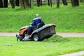 Worker at a lawnmower mowing grass on a platform in front of the Gatchina Palace. Royalty Free Stock Photo