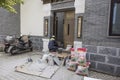 A worker laying floor tiles at the door