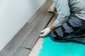 Worker laying floor tiles with wood texture