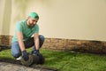 Worker laying grass sod on ground at backyard Royalty Free Stock Photo