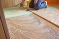 Worker laying insulation layer and spreading adhesive primer