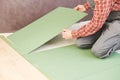 Worker laying laminate floor underlayer padding