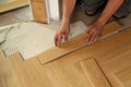 Worker laying parquet flooring. Worker installing wooden laminate flooring Royalty Free Stock Photo