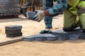 A worker laying paving stones at a sidewalk construction site, close up. Royalty Free Stock Photo