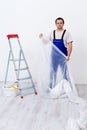 Worker laying protection film before painting Royalty Free Stock Photo