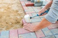 Worker laying red and gray concrete paving blocks. Road Paving, construction Royalty Free Stock Photo