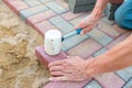 Worker laying red and gray concrete paving blocks. Road Paving, construction Royalty Free Stock Photo