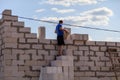 Worker lays bricks at a house construction