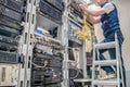 Worker lays communication cables. Technological concept.Technician standing on a ladder connects internet wires. The specialist Royalty Free Stock Photo