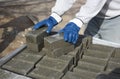 A worker lays out paving slabs, cement bricks on a pallet. Royalty Free Stock Photo