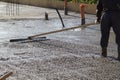 worker leveling fresh concrete slab with a special wooden workin Royalty Free Stock Photo