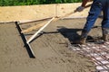 worker leveling fresh concrete slab with special working tool Royalty Free Stock Photo