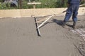 worker leveling fresh concrete slab with special working tool Royalty Free Stock Photo