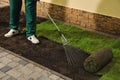 Worker leveling soil before laying grass sod at backyard, closeup Royalty Free Stock Photo