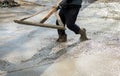 Worker leveling with wooden trowel the fresh poured concrete or cement at construction site Royalty Free Stock Photo