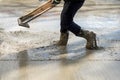 Worker leveling with wooden trowel the fresh poured concrete or cement at construction site Royalty Free Stock Photo