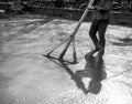 Worker leveling with wooden trowel the fresh poured concrete or cement at construction site Royalty Free Stock Photo