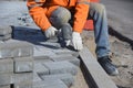 A worker levels the paving slabs laid out with a hammer. Royalty Free Stock Photo