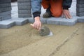 A worker levels the sand before laying the road tiles.