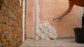 Construction notched trowel and worker hands with white mortar on wall. Worker levels a wall with mortar Royalty Free Stock Photo