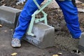 Worker lifts concrete curb with a manual lifting tool. Royalty Free Stock Photo