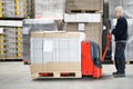 Worker With Loaded Handtruck In Warehouse Royalty Free Stock Photo