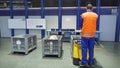 Worker on loader transports boxes in warehous. Scene. Worker standing on loader controls it to transport cargo boxes in