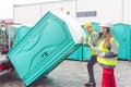 Worker loading portable toilets on truck