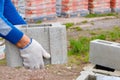 Worker loads cinder blocks from cement slurry for construction