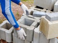Worker loads cinder blocks from cement slurry for construction
