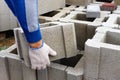 Worker loads cinder blocks from cement slurry for construction