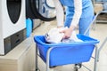 The worker loads the Laundry clothing into the washing machine
