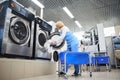 The worker loads the Laundry clothing into the washing machine