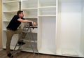 Worker looking at wardrobe. Cabinet assembly concept. Royalty Free Stock Photo