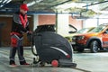 Worker with machine cleaning floor in parking garage. Royalty Free Stock Photo