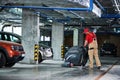 Worker with machine cleaning floor in parking garage.