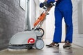 Worker with machine cleaning floor in residence hall Royalty Free Stock Photo