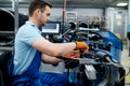Worker with machine tool installs bicycle spokes Royalty Free Stock Photo