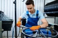 Worker with machine tool installs bicycle spokes Royalty Free Stock Photo