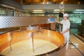 Worker makes cheese at a cheese factory in Gruyeres, Switzerland.