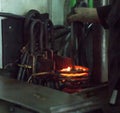 The worker makes hardening heat treatment of the metal gear on a special machine, close-up, hardening of metal