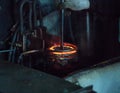 The worker makes hardening heat treatment of the metal gear on a special machine, close-up, hardening of metal, quenching Royalty Free Stock Photo