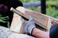 The worker makes a marking on the log before the building of the blockhouse and uses wooden dowel as a ruler markup